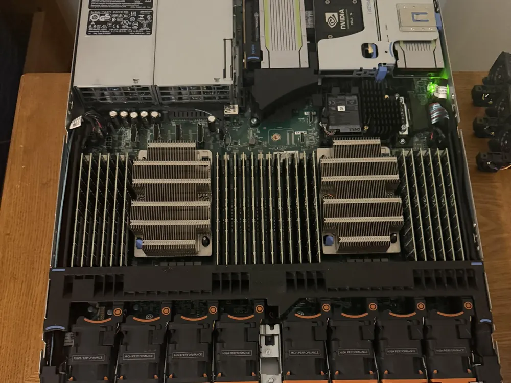 Serveur de baie Dell ouvert vu de dessus : deux alimentations, une carte NVIDIA Tesla T4 sur son support, deux dissipateurs de processeur, les barrettes de mémoire et la rangée de ventilateurs remplaçables à chaud.